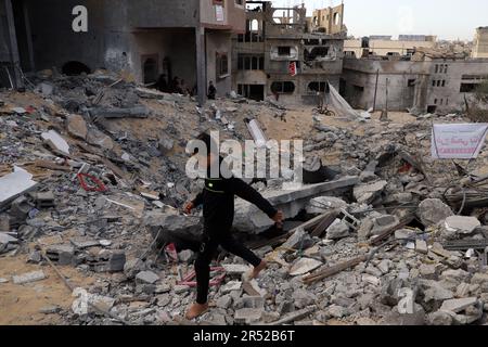 Gaza. 30th May, 2023. A Palestinian boy walks on a house after it was destroyed in an airstrike in the northern Gaza Strip town of Beit Lahia on May 30, 2023. Credit: Rizek Abdeljawad/Xinhua/Alamy Live News Stock Photo