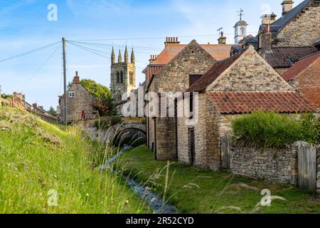 HELMSLEY, NORTH YORKSHIRE, UK - MAY 29, 2023.  Traditional stone buildings and small village stream running through the popular tourist destination of Stock Photo