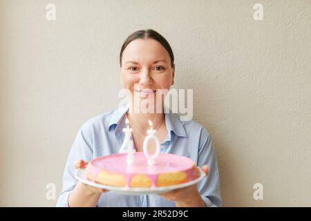 Happy middle age 40 year old woman holding cake with candles Stock ...