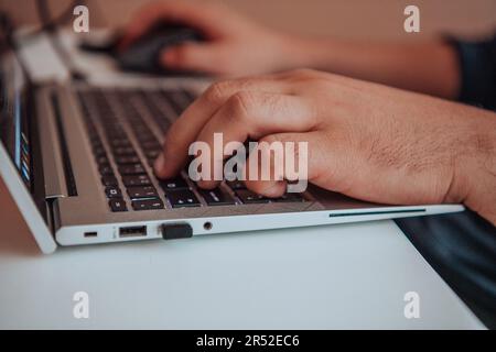 Close-up photo of a programmer typing on a laptop Stock Photo