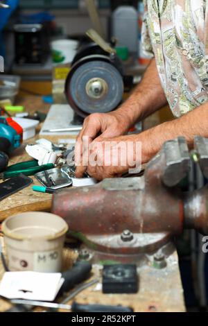 Senior working in workshop with different tools Stock Photo