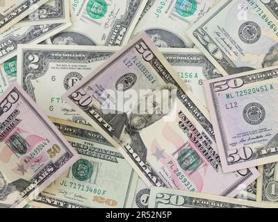 Numerous Fifty, Twenty, One and Two Dollar Bills Laying Flat on a Table - Odd Unique US Currency Stock Photo