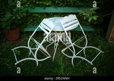 Metal chairs, metal table and wooden bench in garden, Stuttgart, Baden-Wuerttemberg, Germany Stock Photo