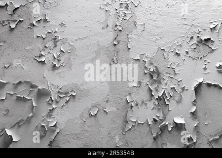 White cracked paint on the wall. Old painted wall. Grungy cracked white wall paint peeling off. Surface paint on the walls are damaged. Stock Photo