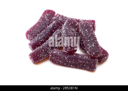 Pile of purple sugary jelly candies isolated on white background. Gummy worms treat Stock Photo