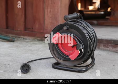 Electrical Long Extension cable cord on reel with remote socket outdoor Stock Photo