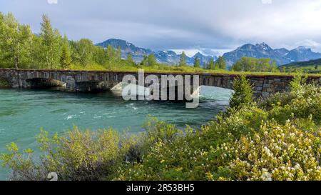 Saint Mary River Bridge - A wide-angle view of Saint Mary River Bridge on a Spring evening in Glacier National Park. Montana, USA. Stock Photo