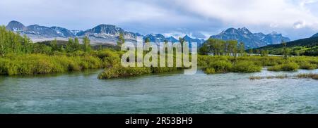 Saint Mary River - Panoramic view of Saint Mary River flowing at base of rugged high peaks of Lewis Range on a Spring evening, Glacier National Park. Stock Photo