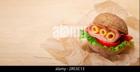 Banner with Ham and swiss cheese sandwich on whole wheat bread on wooden background with copy space Stock Photo
