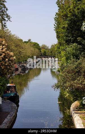 LONDON, UK - MAY 27, 2023:  View along the Grand Union Canal lined with moored Narrowboats where it joins the Regents Canal at Little Venice. Stock Photo