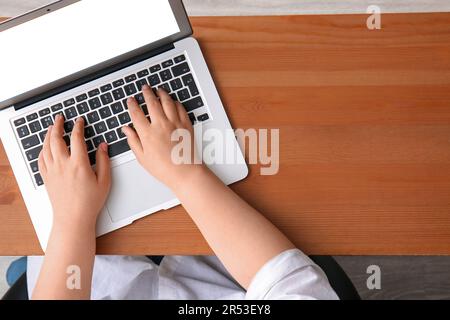 Female programmer using laptop on wooden table Stock Photo