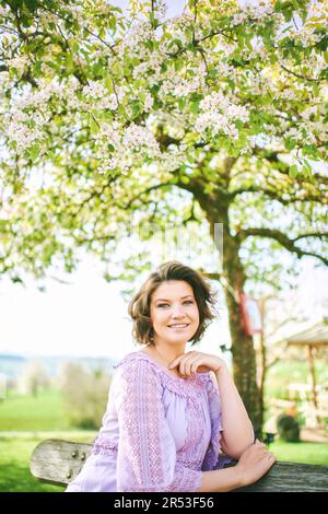 Outdoor spring portrait of happy young woman enjoying nice sunny day Stock Photo
