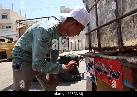 A Palestinian activist puts sign on a cart as he conducts the initiative of 'Horse Etiquette' in Deir al-Balah City central Gaza Strip. Palestinian activists are implementing an initiative called 'A Horse on Etiquette'. They put diapers for animals, which are implemented by the Seeds Theater Association for Culture and Arts, funded by the Abdul Mohsen Qattan Cultural Foundation, which targets animals that pull carts in order to reduce street pollution due to the excrement of these animals to preserve the environment in Deir al-Balah City central Gaza Strip. (Photo by Ahmed Zakot/SOPA Images/ Stock Photo