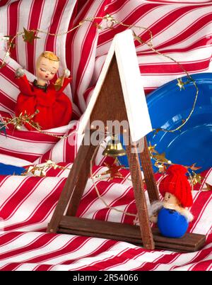 Ring the bell for Christmas. Angel, gnome child with red hat are around bell tower. Swirls of red & white stripes & blue bowl surround the scene. Stock Photo