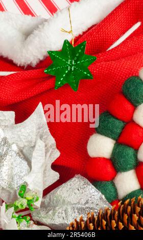 Christmas display closeup of green ornament, red & white fabric with poinsettia and small center text space with texture. Stock Photo