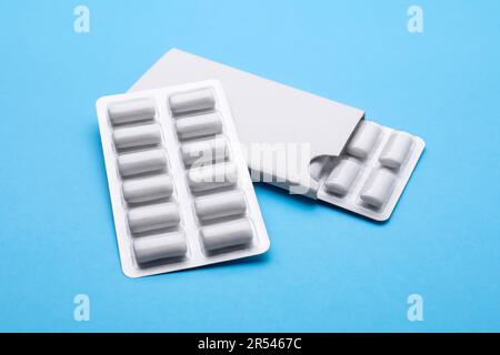 Blisters with chewing gums on light blue background Stock Photo