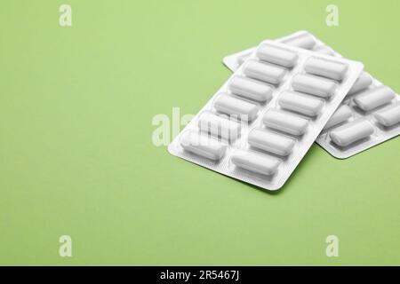 Blisters with chewing gums on pale green background. Space for text Stock Photo