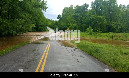 Flash flood water rushes over a low-water bridge on a rural highway near Long Lane, Missouri, MO, United States, US, USA. Stock Photo