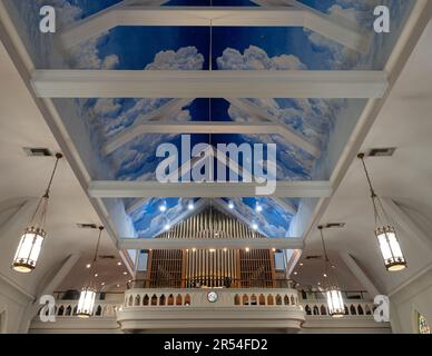 Pipe organ on church mezzanine and handpainted sky and cloud mural on the ceiling in St. Matthew Catholic Church in Monroe, Louisiana. Stock Photo