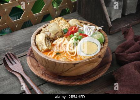 Delicious Curry Noodles or Malay named Mee Kari. Serve with dried tofu, chicken, fish ball, bean sprouts, chili slice, and egg Stock Photo