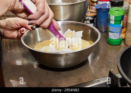 Chef in the home kitchen mixes mashed potatoes with sour cream. Stock Photo