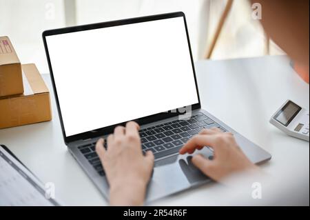 Close-up image of a female online business owner or website admin replying to messages and confirming customer orders on the website through her lapto Stock Photo