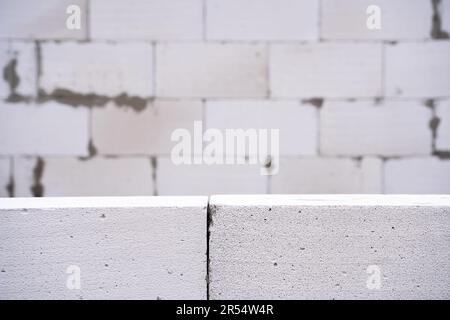 Background wallpaper from a wall of aerated concrete bricks. Aerated concrete block foreground and blurred background Stock Photo