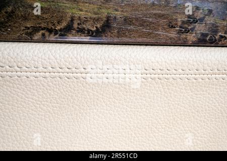 Close-up view of stitches on the car door trims with beige leather. Modern car door interior Stock Photo