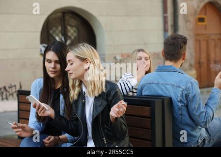 People smoking cigarettes at public place outdoors Stock Photo