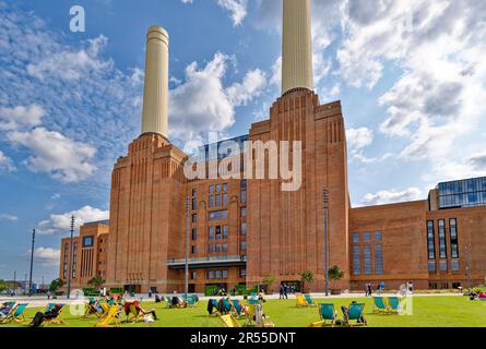 London Wandsworth Battersea Power Station sunshine blue sky and people in deck chairs on a green lawn Stock Photo