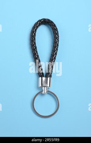 Black leather keychain on light blue background, top view Stock Photo