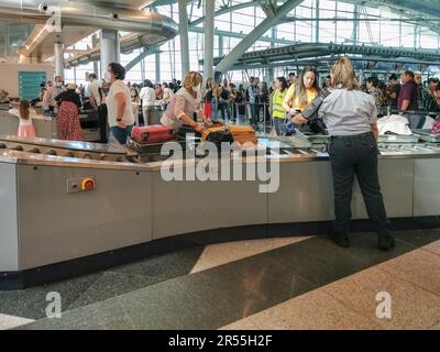 Oporto Portugal 05 08 2022: View of travelers placing handbags on the mat to be inspected in the x-ray machine, police officers inspecting and control Stock Photo