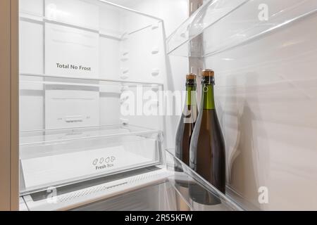 Close-up of two bottles standing in a refrigerator on a door shelf in an empty refrigerator. The concept of alcoholic drinks or alcoholism Stock Photo
