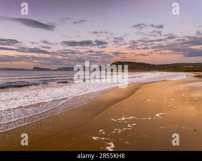 Sunrise with scattered clouds and small waves at Ocean Beach in Umina Beach on the Central Coast, NSW, Australia. Stock Photo