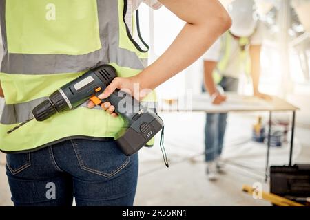 Construction, handyman and drill in hand for maintenance or carpenter work. Back of engineer, constructor or contractor person with electric power Stock Photo