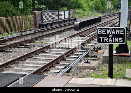 Beware of Trains sign beside a foot crossing at Broadway station on the Gloucestershire Warwickshire Steam Railway. Stock Photo