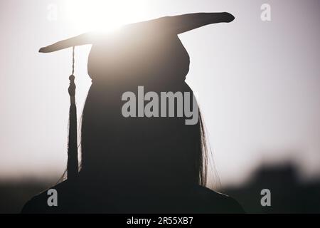Graduation, education and silhouette of a student woman outdoor on university campus with lens flare. Future, college and scholarship with a female Stock Photo