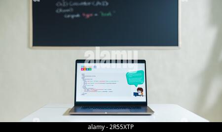 Laptop showing a computer programme placed on a desk in a children’s coding classroom. Still life shot of a lesson setup in a kids coding academy. Stock Photo