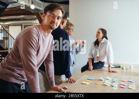 business man having a meeting with his team in a marketing agency. Creative business people brainstorming in an office. Group of professionals working Stock Photo