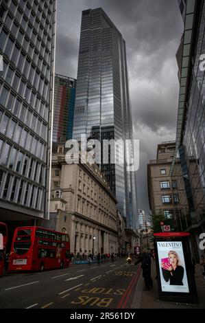 London, UK: Bishopsgate in the City of London with people and red buses. The 22 Bishopsgate skyscraper is set against a backdrop of dark storm clouds. Stock Photo