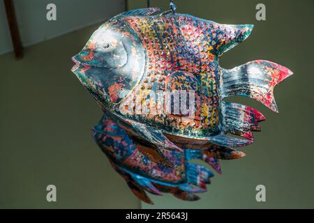 A decorative fish made from recycled scrap metal hangs at Pumulani Lodge (Robin Pope Safaris) on Lake Malawi near Kasankha, Malawi. Such fish sculptures crafted from repurposed material are a recurring design feature of the lodge. With around 700 to 800 species of cichlid, the lake ranks as the most species-rich freshwater lake in the world. Stock Photo