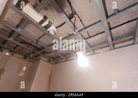 Man assembles profile metal frame for plasterboard ceilings Stock Photo