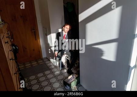 student teenager in black suit is about to leave from home to pass an secondary school-leaving exam - series Stock Photo