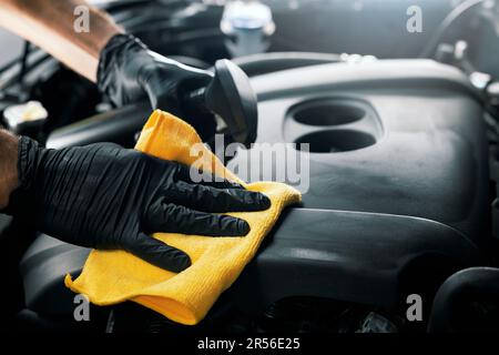 man cleaning car engine room with microfiber cloth and spray. auto detailing Stock Photo