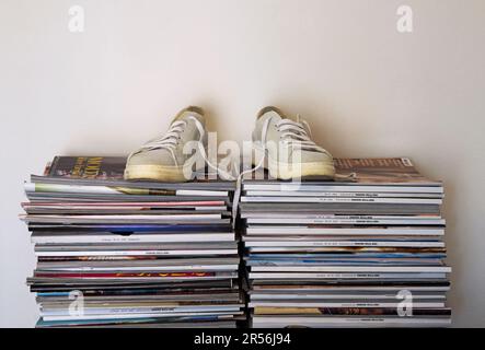 stack of magazines with a pair of sneakers on the top Stock Photo