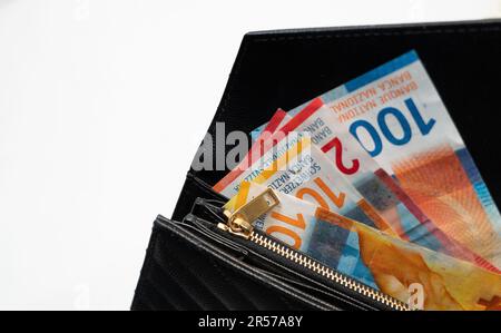 swiss franc money.  Paper money in a black, leather wallet close up. Cash of paper currency background, isolated on white background. CHF. Stock Photo
