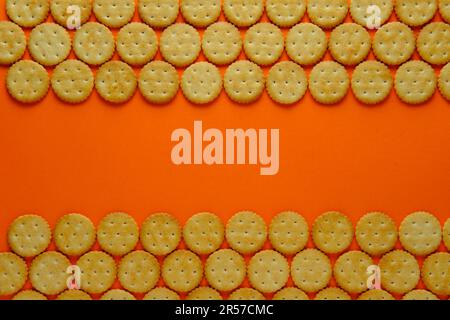 Crackers in repeating rows against a plain background. Top down view. Stock Photo