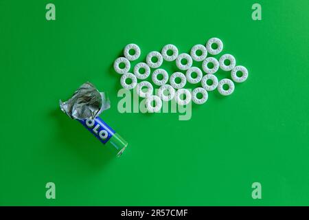 A pile of Polo mint sweets against a plain green background. Top-down view. Stock Photo
