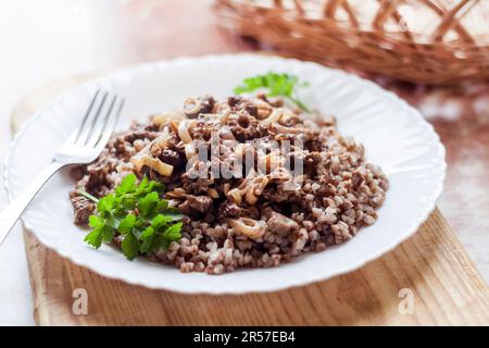 Spring Morel mushrooms stewed in sour cream, served with buckwheat on white plate Stock Photo