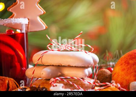 Christmas celebration concept with Christmas cookies and cup of mulled wine, close up with selective focus on the background of the Christmas tree Stock Photo